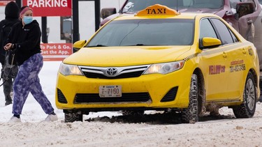 A rider gets out of a Yellow Cab taxi in downtown Edmonton, on Saturday, March 5, 2022. Advocacy groups are demanding action to improve safety and accessibility in taxis and rideshare services.