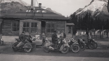 On the road to Banff at an unidentified cafe near Canmore with the Ace-Hy Motorcycle Club of Calgary. Tourist cabins appear in the right of the image.