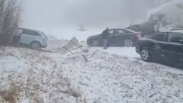An out-of-control vehicle approaches a driver that stepped out, amid a pileup during snow and fog on I-81 North, in Schuylkill County, Pennsylvania, U.S., March 28, 2022 in this still image taken from social media video.