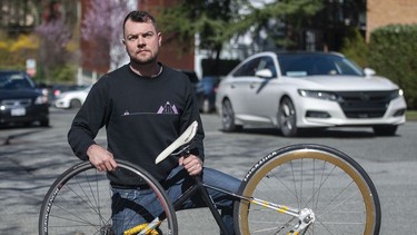 Ben Bolliger holds his broken bicycle on Wednesday at Willow Street and West 7th Avenue in Vancouver, where he was hit by a young driver behind the wheel of a Mercedes last July.