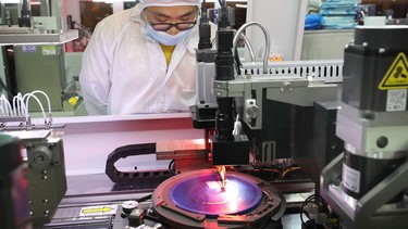 An employee makes chips at a factory of Jiejie Semiconductor Company in Nantong, in eastern China's Jiangsu province on March 17, 2021.