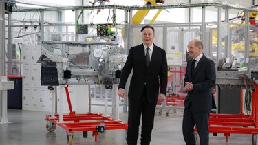 Tesla CEO Elon Musk stands next to German Chancellor Olaf Scholz during the official opening of the new Tesla electric car manufacturing plant on March 22, 2022 near Gruenheide, Germany.