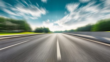 Fast moving road and green forest landscape.