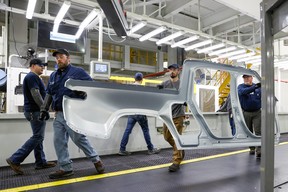 Mitarbeiter arbeiten an einem Fließband in der Elektrofahrzeugfabrik des Startups Rivian Automotive in Normal, Illinois, USA, 11. April 2022.