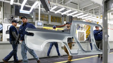 Employees work on an assembly line at startup Rivian Automotive's electric vehicle factory in Normal, Illinois, U.S. April 11, 2022.