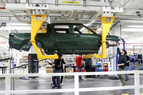 Mitarbeiter arbeiten an einem Fließband in der Elektrofahrzeugfabrik des Startups Rivian Automotive in Normal, Illinois, USA, 11. April 2022.