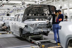 Mitarbeiter arbeiten an einem Fließband in der Elektrofahrzeugfabrik des Startups Rivian Automotive in Normal, Illinois, USA, 11. April 2022.