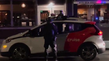 A screenshot of a San Francisco police officer pulling over a Cruise robotaxi without a driver