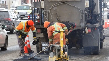 A work crew from Bruce Tait Construction Ltd. repairs a section of road on Notre Dame Avenue on March 11 .
