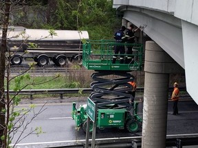 OPP measure the height of the North Park Street bridge over Highway 403 where it was struck Wednesday by a passing vehicle.