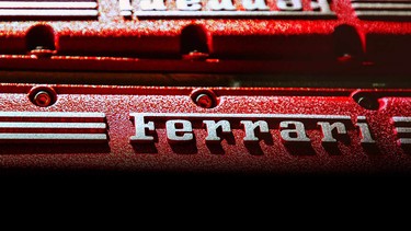 A closeup of the Ferrari logo on the valve cover of a V12 engine