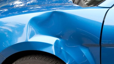Close up of a blue car that's been damaged.