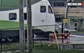 Ein Screenshot aus einem von Metrolinx veröffentlichten Video eines Autos, das kurz davor steht, von einem GO Transit-Zug angefahren zu werden, nachdem es die Barriere umgangen hat.