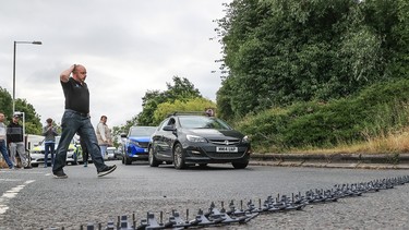 Police deploy a stinger spike strip to block the exit to and from a U.K. service station, stopping protestors leaving during a fuel protest on the M62 near Pontefract, West Yorkshire, U.K., on July 4, 2022.