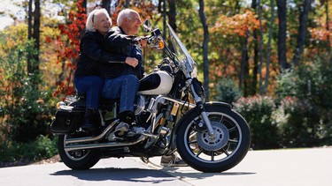 An older man and woman on a motorcyle