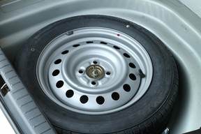 Full-sized spare wheel in storage well under a trunk floor