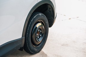 Small family car with a spare donut tire mounted to replace a flat tire