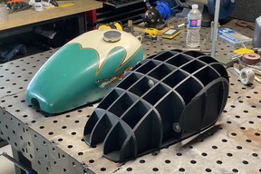 Kaetyn St. Hilaire’s rare Triumph TR5 gas tank in a custom period paint scheme (left). He had help 3D scanning the original and had a buck printed in 3D plastic and plans to produce a replica Triumph tank using an English wheel. CREDIT: Kaetyn St. Hilaire