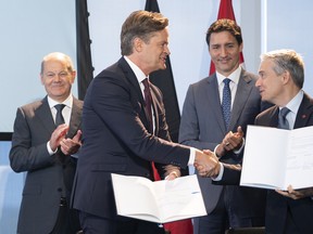 Le chancelier allemand Olaf Scholz (à l'extrême gauche) et le premier ministre canadien Justin Trudeau (2e à partir de la droite) se tiennent derrière Markus Schaefer (à gauche), membre du conseil d'administration de Mercedes-Benz; et François-Philippe Champagne, ministre de l'Innovation, des Sciences et de l'Industrie du Canada, lors de la signature de protocoles d'entente.