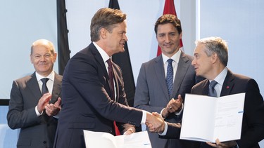 German Chancellor Olaf Scholz (far left) and Canadian Prime Minister Justin Trudeau (2nd from right) stand behind Markus Schaefer (left), member of the Board of Management of Mercedes-Benz Group; and François-Philippe Champagne, Minister of Innovation, Science and Industry of Canada, at the German-Canadian Business Forum as they sign a memorandum of understanding