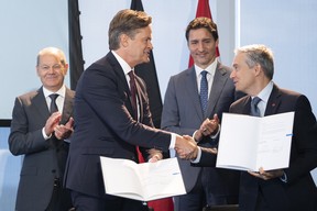 German Chancellor Olaf Scholz (far left) and Canadian Prime Minister Justin Trudeau (2nd from right) stand behind Markus Schaefer (left), member of the Board of Management of Mercedes-Benz Group; and François-Philippe Champagne, Minister of Innovation, Science and Industry of Canada, at the German-Canadian Business Forum as they sign a memorandum of understanding