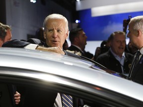 U.S. Vice President Joe Biden peers over a Chevrolet Bolt during a visit to the North American International Auto Show in Detroit, Michigan, U.S., January 10, 2017.