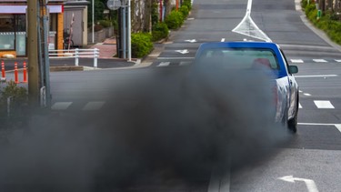 A massive plume of sooty exhaust smoke coming from a diesel pickup truck