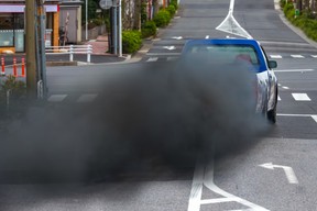 A huge plume of sooty exhaust smoke from a diesel pickup truck