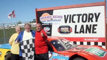 John Klages, center, a resident of Queensway Long Term Care and Retirement Community in Hensall, recently had his dream come true when he was able to ride in a race car at Grand Bend Speedway.  Joining Klages on Wednesday, Sept. 7, are his wife Janice, left, and Speedway co-owner Gord Bennett, right, who drove Klages 10 laps around the track.