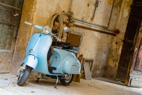 A vintage Vespa scooter in an alleyway in Europe