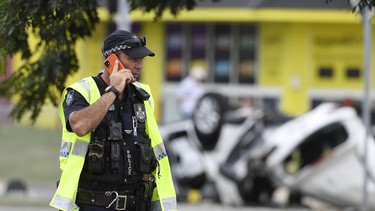 A policeman is seen on his phone at the scene of a car accident involving four teenagers on June 07, 2020 in Townsville, Australia.