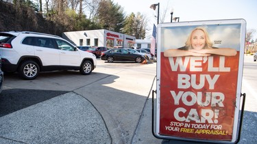 A sign advertises to purchase cars at a used car dealership in Arlington, Virginia, February 15, 2022.