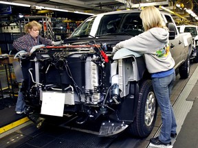 People work on a Chevy pickup truck on the assembly line of the General Motors Flint Assembly Plant January 24, 2011 in Flint, Michigan.
