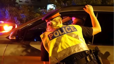 A police officer interacts with a motorist at an impaired driving checkpoint.