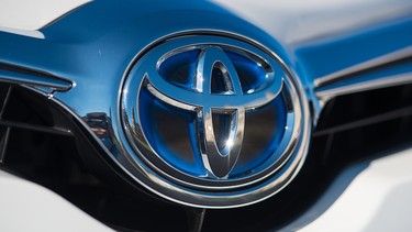 A Toyota badge on the hood of a hybrid Prius