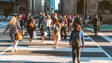 Crowd of unrecognisable people crossing street on traffic light zebra in the city of Toronto at rush hour - Lifestyle in a big city in North America