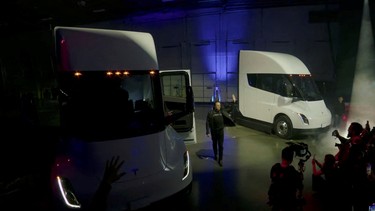 Tesla Chief Executive Elon Musk waves near Tesla Semi electric trucks during a live-streamed unveiling in Nevada, U.S. December 1, 2022, in this still image taken from video
