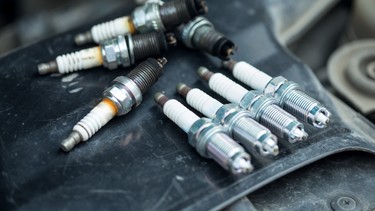 Worn and new spark plugs on the engine