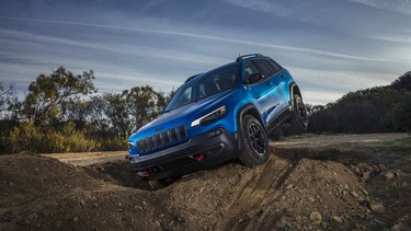 The 2023 Jeep Cherokee Trailhawk crawling over a rock