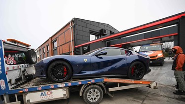 Police transport a Ferrari on a platform out from the site of "The Hustlers University" belonging to controversial influencer Andrew Tate and his brother in Bucharest on January 14, 2023