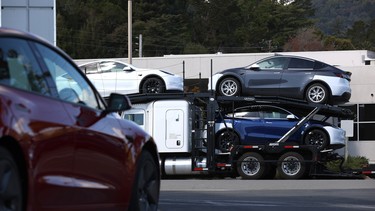 Brand-new Tesla cars sit on a truck outside of a Tesla dealership on April 26, 2021 in Corte Madera, California