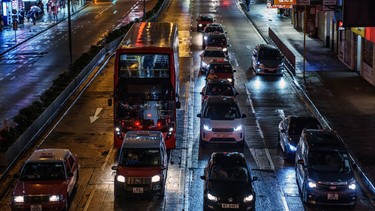 Vehicles travel along a road at night in Hong Kong, China, on Monday, March 28, 2022