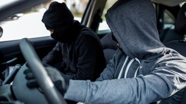 A pair of car thieves inside a stolen vehicle