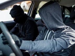 A pair of car thieves inside a stolen vehicle