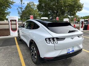 A Ford Mustang Mach-E at at Tesla charging station