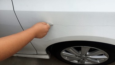 Vandal keying a car fender