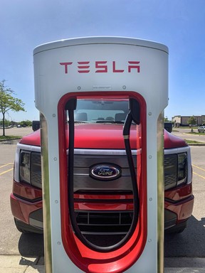 A 2023 Ford F-150 Lightning at a Tesla charging station