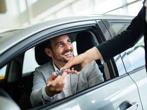 Professional salesperson during work with customer at car dealership.