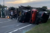 A trailer full of supercars tipped over on its side in the U.K., in August 2023
