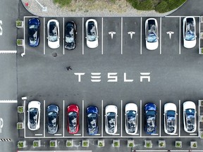In an aerial view, Tesla cars sit parked in a lot at the Tesla factory on April 20, 2022 in Fremont, California